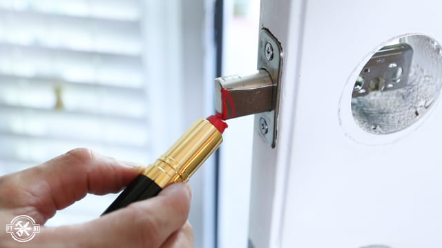 red lipstick on deadbolt in front door