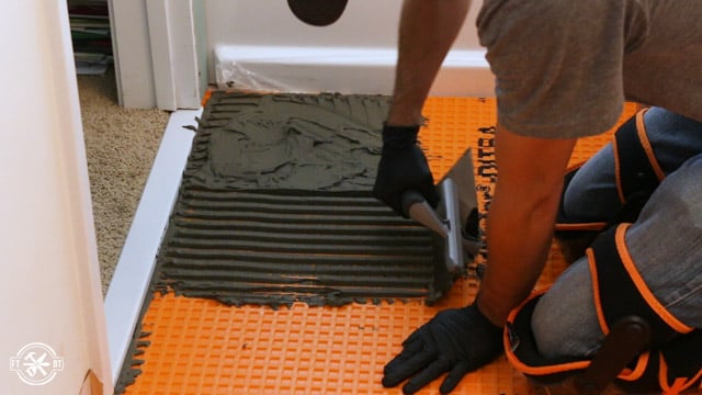 applying mortar to the ditra before placing tiles