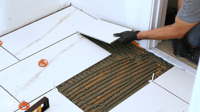 laying the last of the tiles in the room