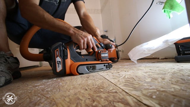 smoothing out floor with belt sander
