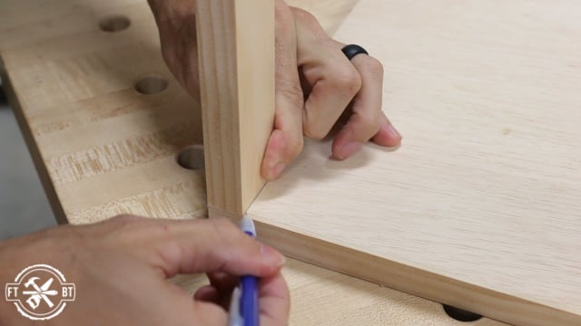 marking the cut for the front stretcher on the wood panel