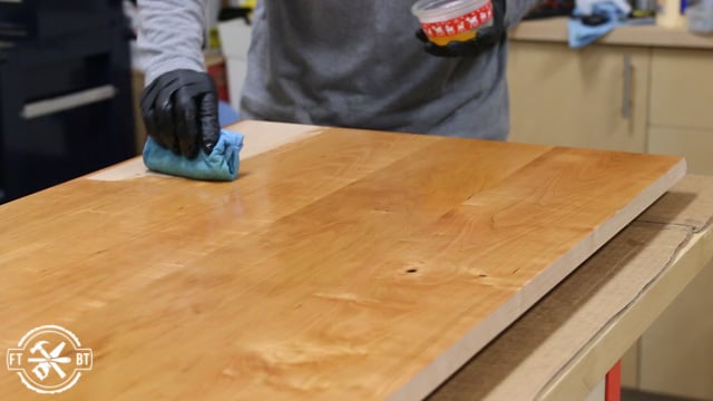applying a coat of oil based polyurethane to wood