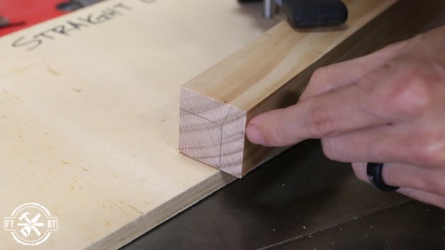 marking wood table leg with pencil to cut