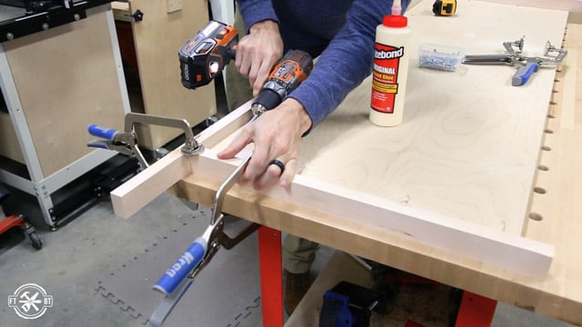 screwing side pieces of wood trim to cabinet top