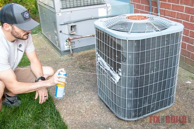 spraying air conditioner cleaner on AC unit