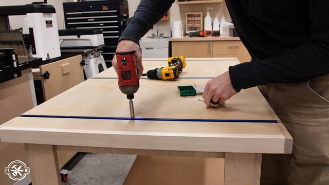 screwing down the t-track to the table saw outfeed table