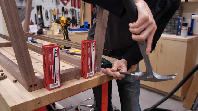 hammering wooden plugs into table legs