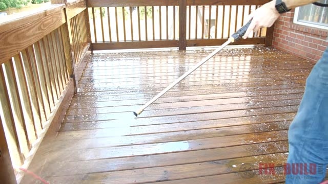 spraying oxalic acid on a deck