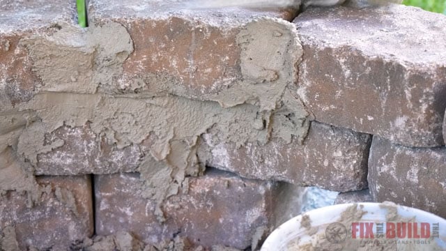adding mortar to inside of stone fire pit